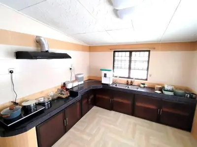 a kitchen with a black counter top in a room at PUTIH Ipoh SaltWater Pool BBQ 5Bed4Bath 19pax in Ipoh
