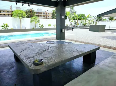 a large stone table in front of a pool at PUTIH Ipoh SaltWater Pool BBQ 5Bed4Bath 19pax in Ipoh