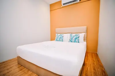 a white bed in a room with an orange wall at Swing & Pillows - Armenian Victoria , Georgetown Penang in George Town