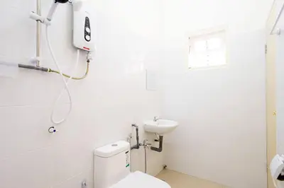 a white bathroom with a toilet and a sink at Sweet 9ight Menglembu Falim Homestay in Ipoh