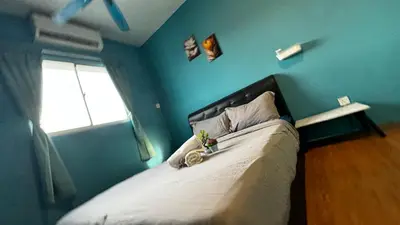 a bedroom with a bed with a blue wall at skyview relax 2BR 1car park arenaspice airport domestic guest only in Bayan Lepas