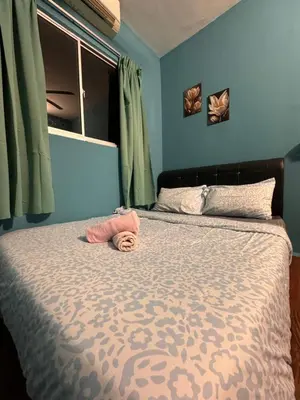 a bedroom with a large bed with blue walls at skyview relax 2BR 1car park arenaspice airport domestic guest only in Bayan Lepas