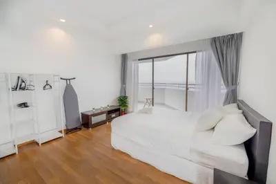 a bedroom with a white bed and a large window at Sri Sayang at Batu Feringghi Beach by Plush in Ayer Itam
