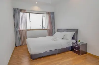 a bedroom with a bed with a window and a table at Sri Sayang at Batu Feringghi Beach by Plush in Ayer Itam