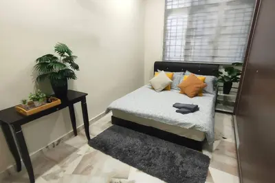 a bedroom with a bed and a table and a window at 66 Homestay 5 Min to Leaning Tower in Teluk Intan