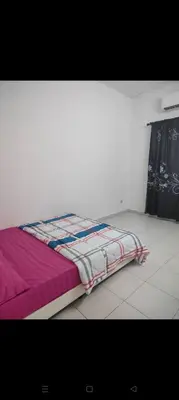 a bed in a room with a purple blanket at Mom House in Ipoh