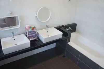 a bathroom with two white sinks and a mirror at Tranquil lake view retreat \u601d\u6e56\u8336\u5c4b in Ipoh