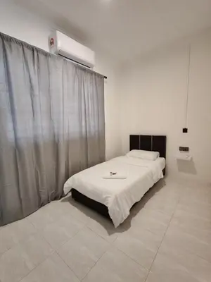 a bedroom with a bed with a white blanket at 23 Inn Singlebed Room with share bathroom in Bukit Mertajam