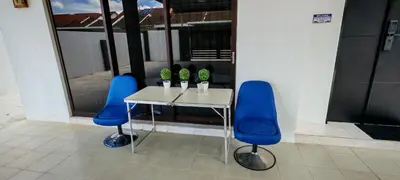 a table and two blue chairs in a room at 23 Inn Singlebed Room with share bathroom in Bukit Mertajam