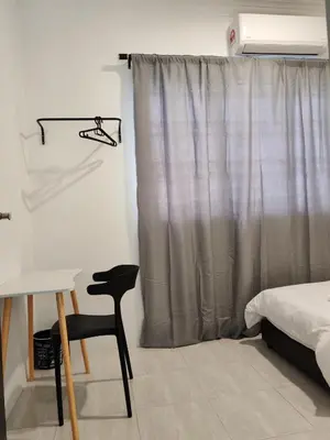 a bedroom with a bed and a chair and a curtain at 23 Inn Singlebed Room with share bathroom in Bukit Mertajam