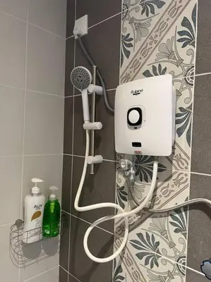 a bathroom with a shower with a hair dryer on a wall at Ipoh Town Anderson Hani Suite 4paxs 1R1B in Ipoh