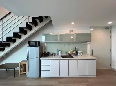 a kitchen with a refrigerator and a staircase at Maritime Suite Duplex 3Bedroom at George Town by Uptrend Home Management in George Town