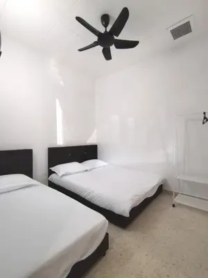 two beds in a room with a ceiling fan at 9pax -Taman Bagan Butterworth -Budget Homestay in Butterworth
