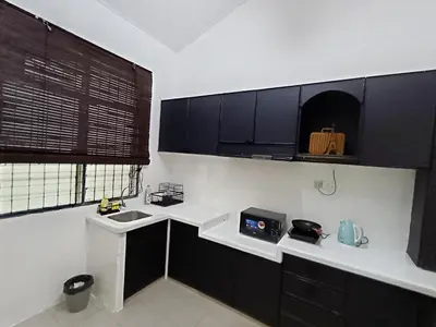 a kitchen with black and white cabinets and a sink at 9pax -Taman Bagan Butterworth -Budget Homestay in Butterworth