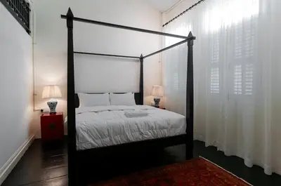 a bedroom with a four poster bed and two lamps at Carnarvon Villa by Aayu George Town Penang in George Town