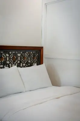 a bed with white sheets and a window at Carnarvon Villa by Aayu George Town Penang in George Town