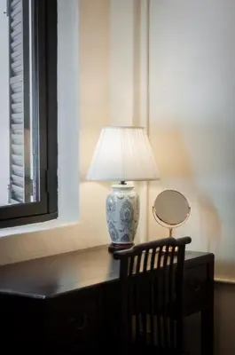 a lamp sitting on a desk next to a chair at Carnarvon Villa by Aayu George Town Penang in George Town