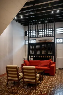 a living room with a red couch and two chairs at Carnarvon Villa by Aayu George Town Penang in George Town