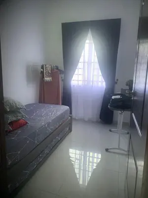 a bedroom with a bed and a window and a desk at HomeStay Damia in Teluk Intan
