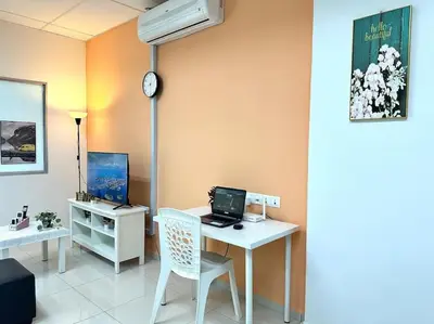 a room with a desk with a computer and a clock at Superb Airport 2BR Suite# Straits Intl# MsgChair in Bayan Lepas