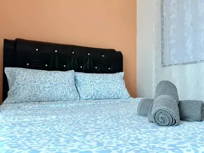 a bed with a stuffed animal laying on it at Superb Airport 2BR Suite# Straits Intl# MsgChair in Bayan Lepas