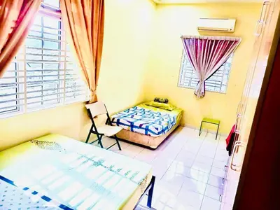 a bedroom with a bed and a chair and a window at Lavender Homestay Tanjung Malim in Tanjung Malim