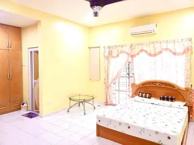 a bedroom with a bed and a table and a window at Lavender Homestay Tanjung Malim in Tanjung Malim