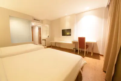 a hotel room with two beds and a desk at Hotel Malaysia in George Town
