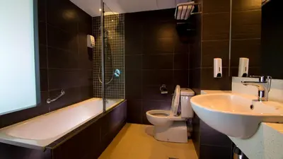 a bathroom with a sink and a tub and a toilet at Hotel Malaysia in George Town