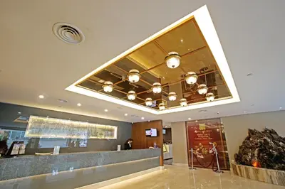 a restaurant with a ceiling with a chandelier at Hotel Malaysia in George Town