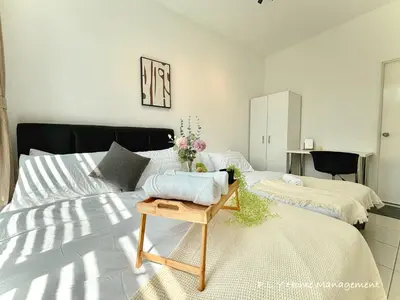 a bedroom with two beds and a table at The Anderson Condo by PLY Home in Ipoh