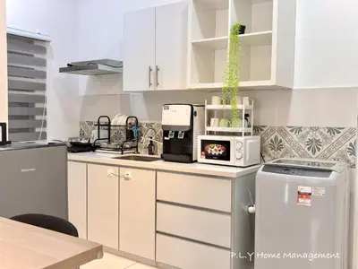 a kitchen with white cabinets and a microwave on a counter at The Anderson Condo by PLY Home in Ipoh