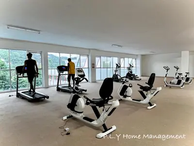 two people in a gym with treadmills and exercise bikes at The Anderson Condo by PLY Home in Ipoh