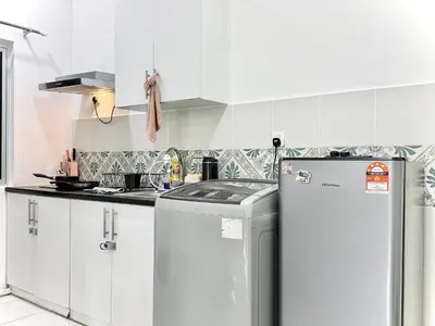 a kitchen with white cabinets and a refrigerator at The Anderson Condo by PLY Home in Ipoh