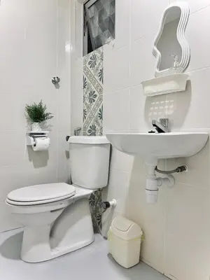 a white bathroom with a toilet and a sink at The Anderson Condo by PLY Home in Ipoh