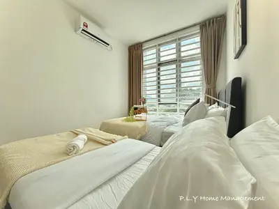 two beds in a room with a window at The Anderson Condo by PLY Home in Ipoh