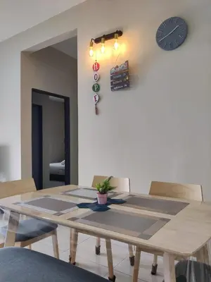 a dining room table with a clock on the wall at feelslikehome Paloh Residence Ipoh-for 4 to 6pax in Ipoh