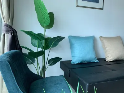 a living room with a chair and a plant at The Rain Homestay Meru Raya in Ipoh