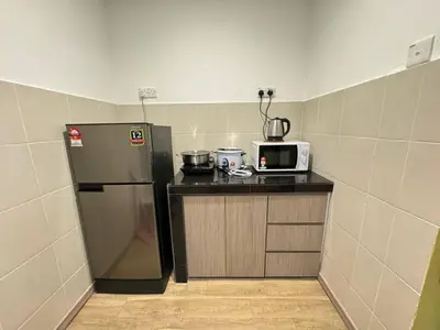 a small kitchen with a refrigerator and a microwave at Eisya Homestay Emerald Avenue Brinchang in Brinchang