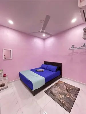 a bedroom with a blue bed in a pink wall at Ammaiti Homestay Kulim in Kulim