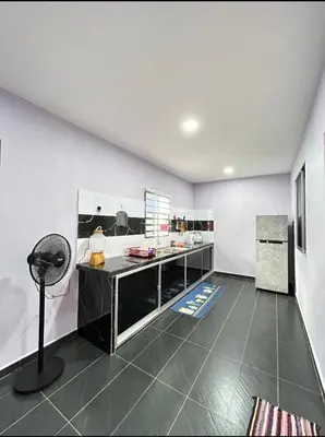 a kitchen with a counter in a room with a floor at Ammaiti Homestay Kulim in Kulim