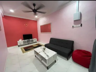 a living room with a black couch and a red wall at Ammaiti Homestay Kulim in Kulim