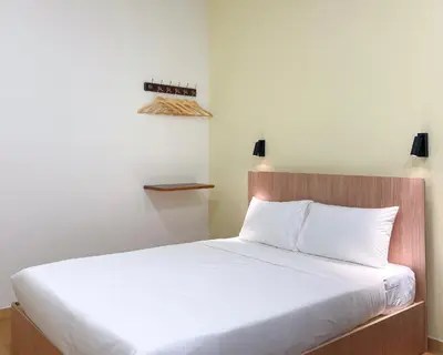 a bedroom with a large bed with white sheets at INN Lebuh Melayu in George Town
