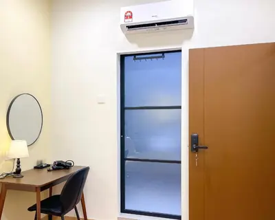 a refrigerator in a room with a desk and a mirror at INN Lebuh Melayu in George Town