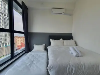 a bedroom with two beds and a large window at Urban Suites Penang P2 LDL WL in Jelutong