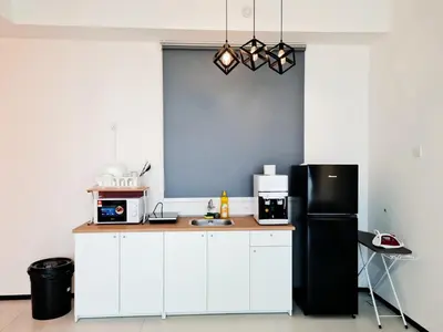 a kitchen with white cabinets and a black refrigerator at Urban Suites Penang P2 LDL WL in Jelutong