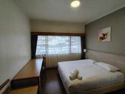 a bedroom with a bed with a teddy bear on it at Highland Hideaway 1 Bedroom Apartment at Equatorial Hill Resort in Brinchang