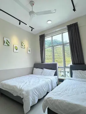 two beds in a room with a window at Penthouse with 3 bedrooms, Golden Hills Night Market in Brinchang