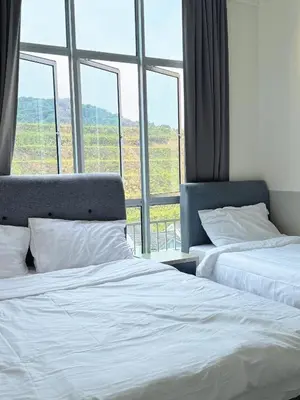two beds in a room with a large window at Penthouse with 3 bedrooms, Golden Hills Night Market in Brinchang