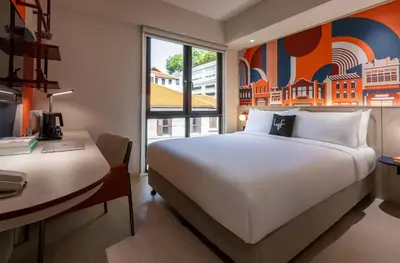 a bedroom with a white bed and a desk and a window at lyf Georgetown Penang in George Town